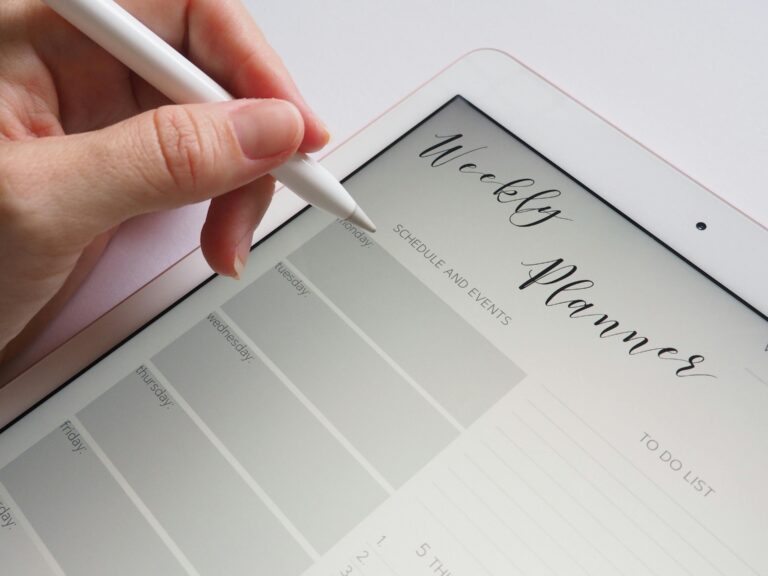 Person using a digital weekly planner to organize short-term goals for long-term success